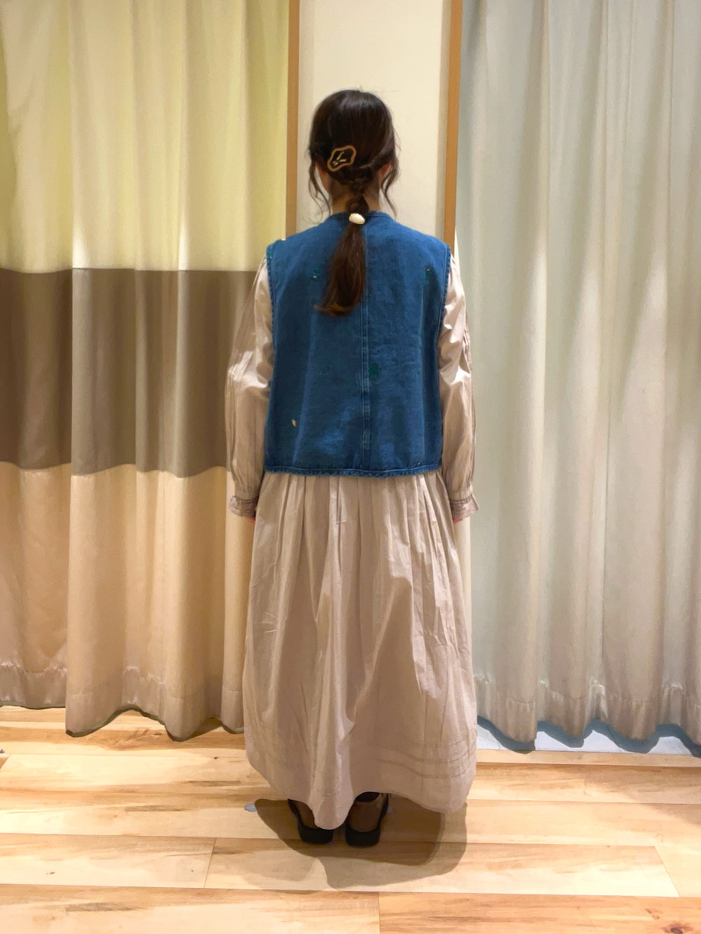 ベージュ系のワンピース、ブルー系のベストを着用したレディースの冬コーディネートの4枚目の写真