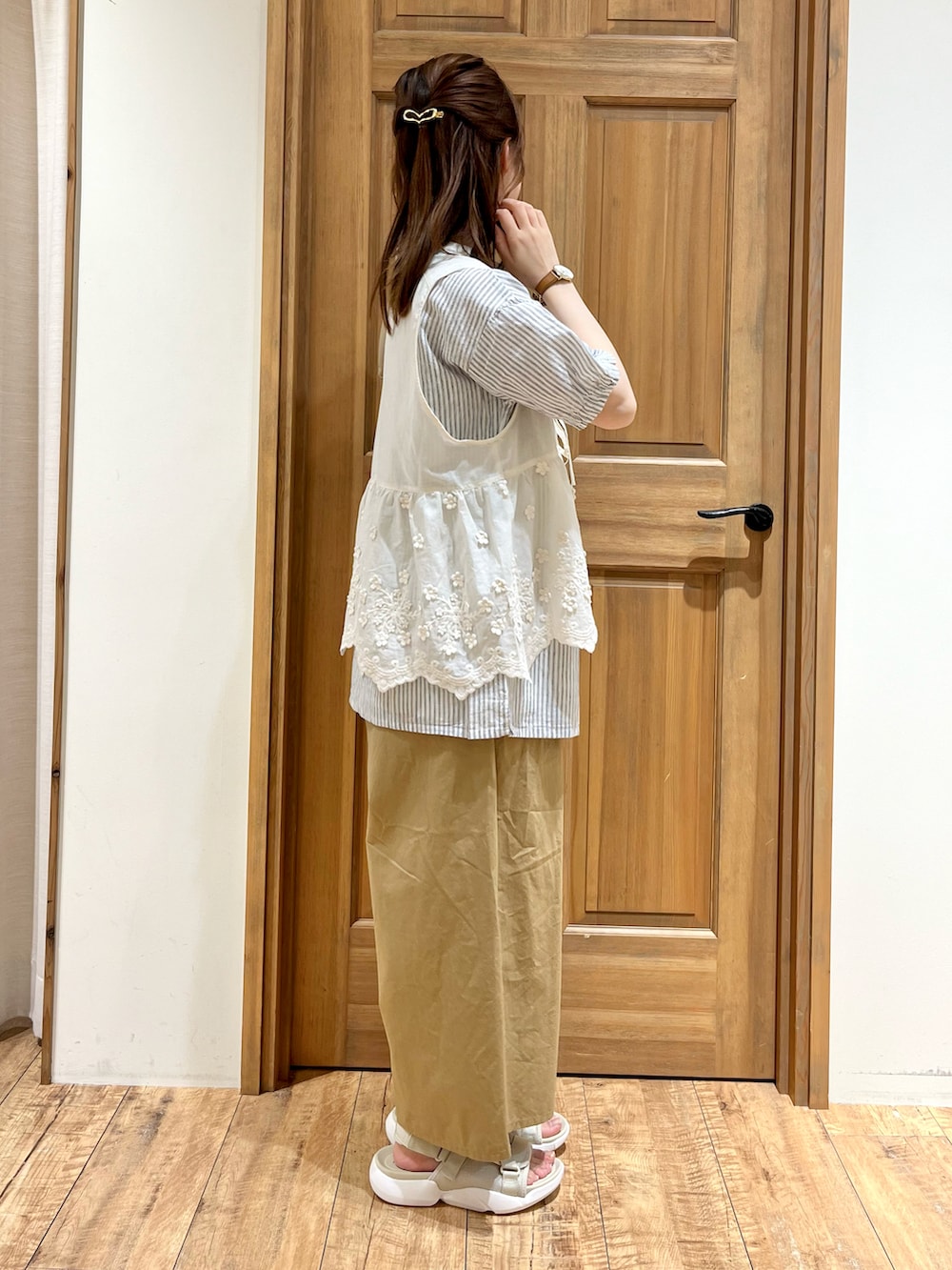 ベージュ系のハンドバッグ、ホワイト系のベスト、ブルー系のシャツ/ブラウスを着用したレディースの夏コーディネートの4枚目の写真