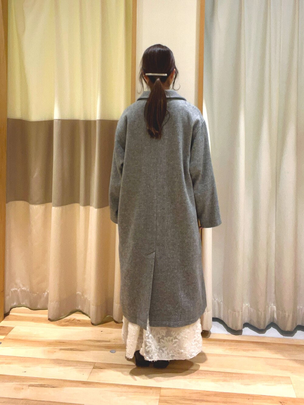 ブルー系のニット/セーター、ホワイト系のスカート、グレー系のその他アウターを着用したレディースの冬コーディネートの4枚目の写真