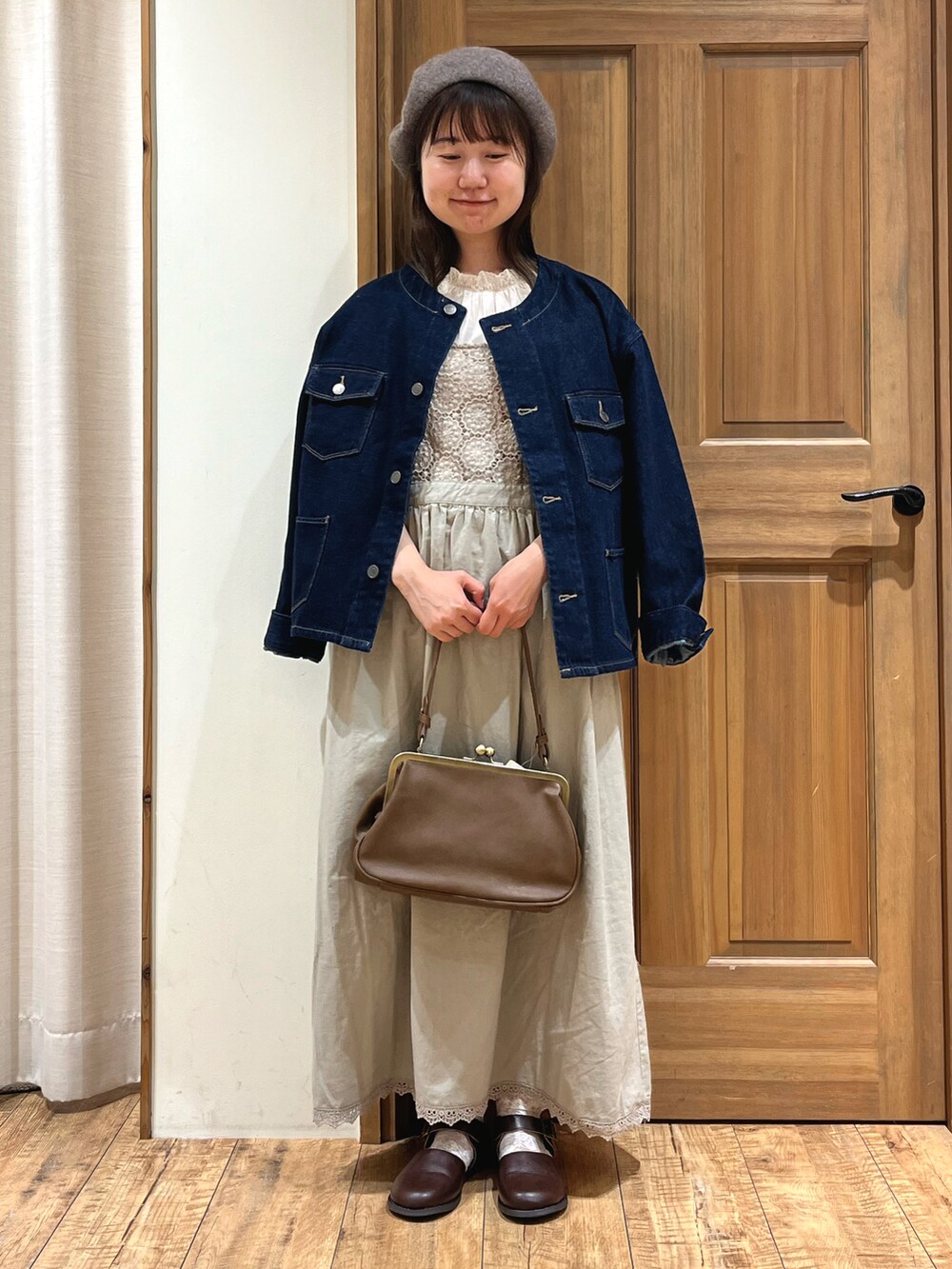 ブラウン系のドレスシューズ、ブルー系のノーカラージャケット、ベージュ系のワンピースを着用したレディースの秋コーディネートの2枚目の写真