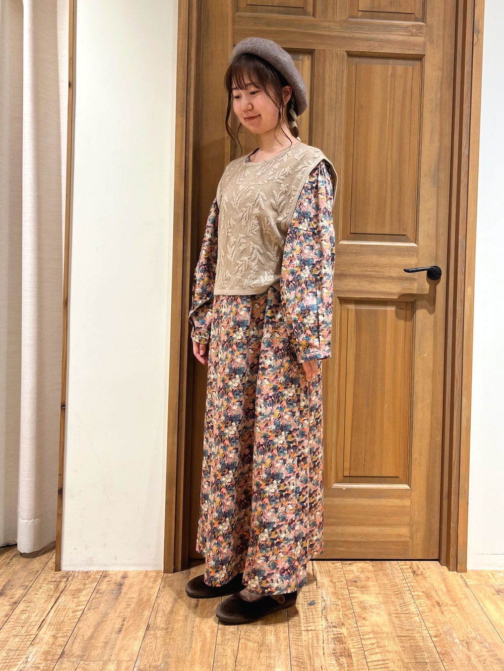ブラウン系のドレスシューズ、ベージュ系のベスト、ピンク系のワンピースを着用したレディースの夏コーディネートの2枚目の写真