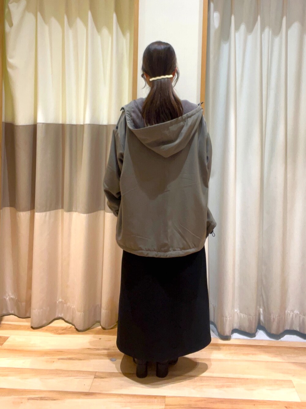 グリーン系のニット/セーター、ブラック系のスカート、ブラック系のドレスシューズを着用したレディースの秋コーディネートの3枚目の写真