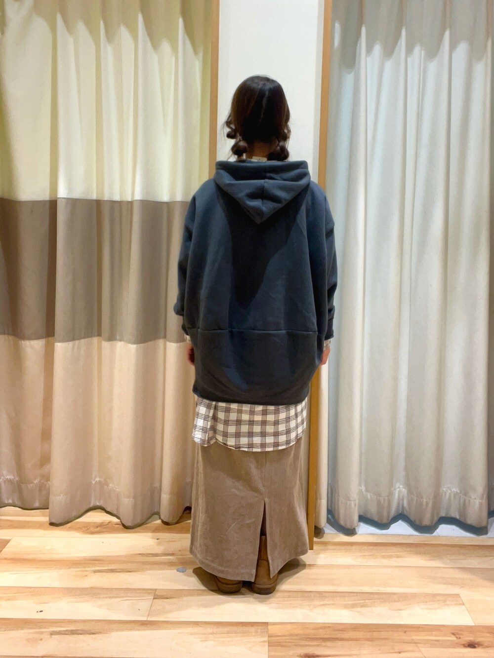 ベージュ系のスカート、グレー系のTシャツ/カットソー、ホワイト系のチュニックを着用したレディースの冬コーディネートの3枚目の写真