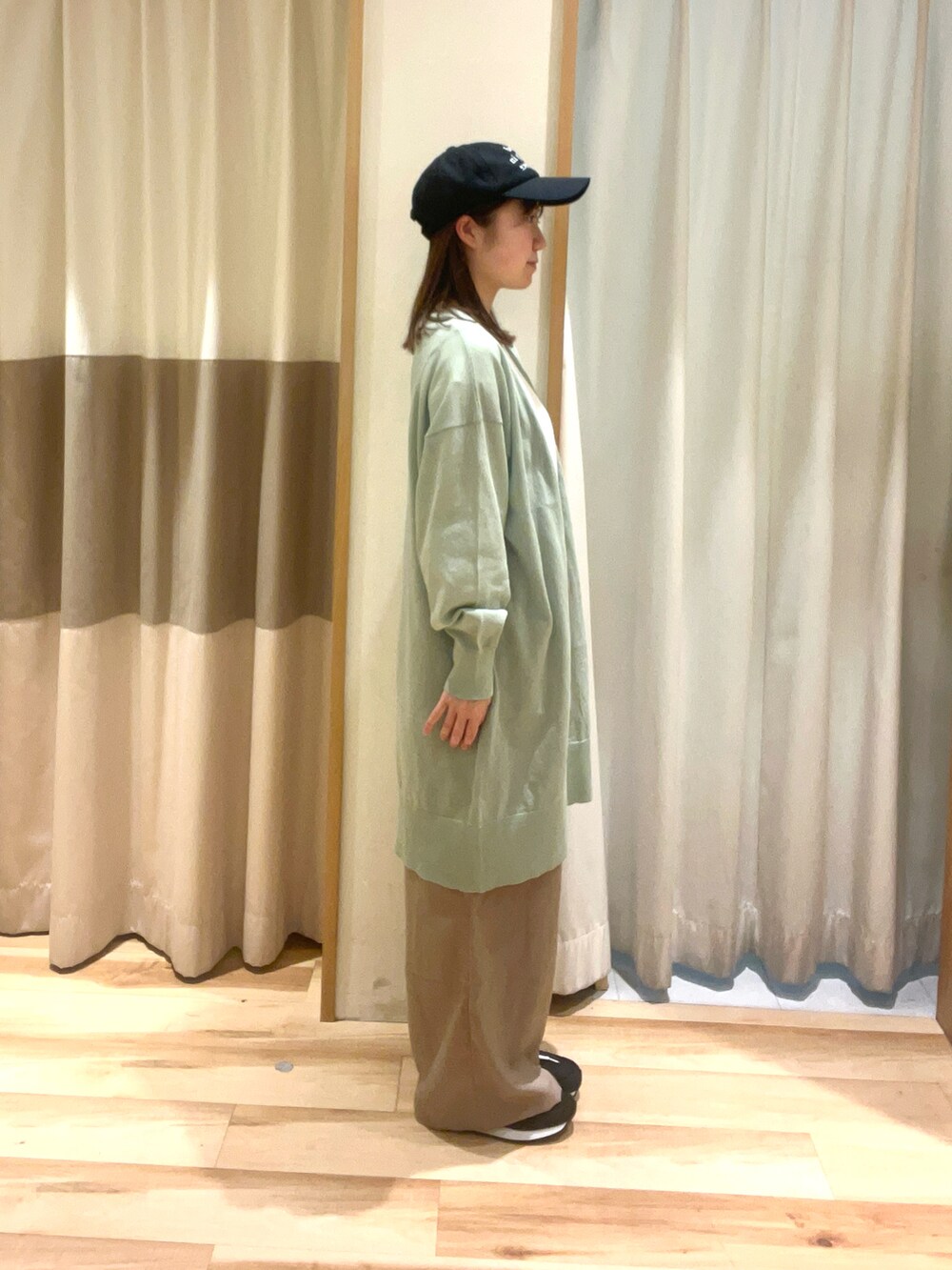 ホワイト系のTシャツ/カットソー、ベージュ系のその他パンツ、グリーン系のカーディガン/ボレロを着用したレディースの春コーディネートの2枚目の写真