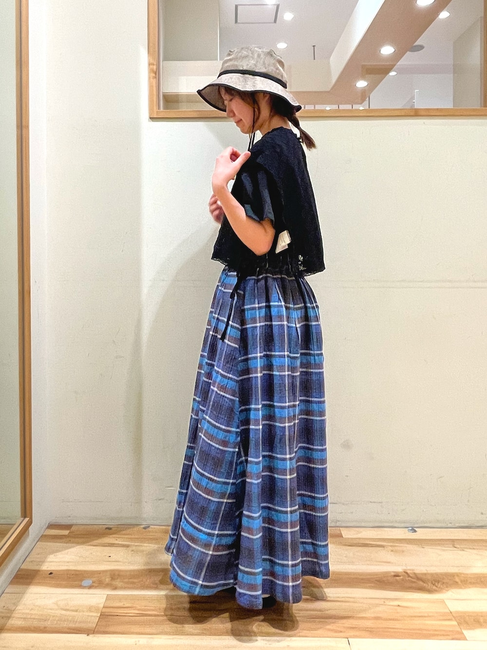 ベージュ系のワンピース、グレー系のTシャツ/カットソー、ブルー系のスカートを着用したレディースの春コーディネートの3枚目の写真