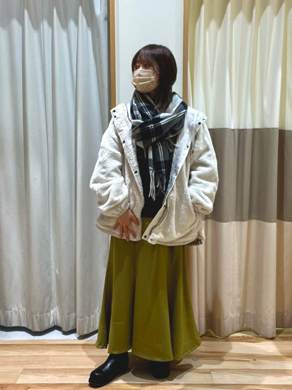 パープル系のTシャツ/カットソー、ホワイト系のマウンテンパーカー、イエロー系のスカートを着用したレディースの冬コーディネートの3枚目の写真