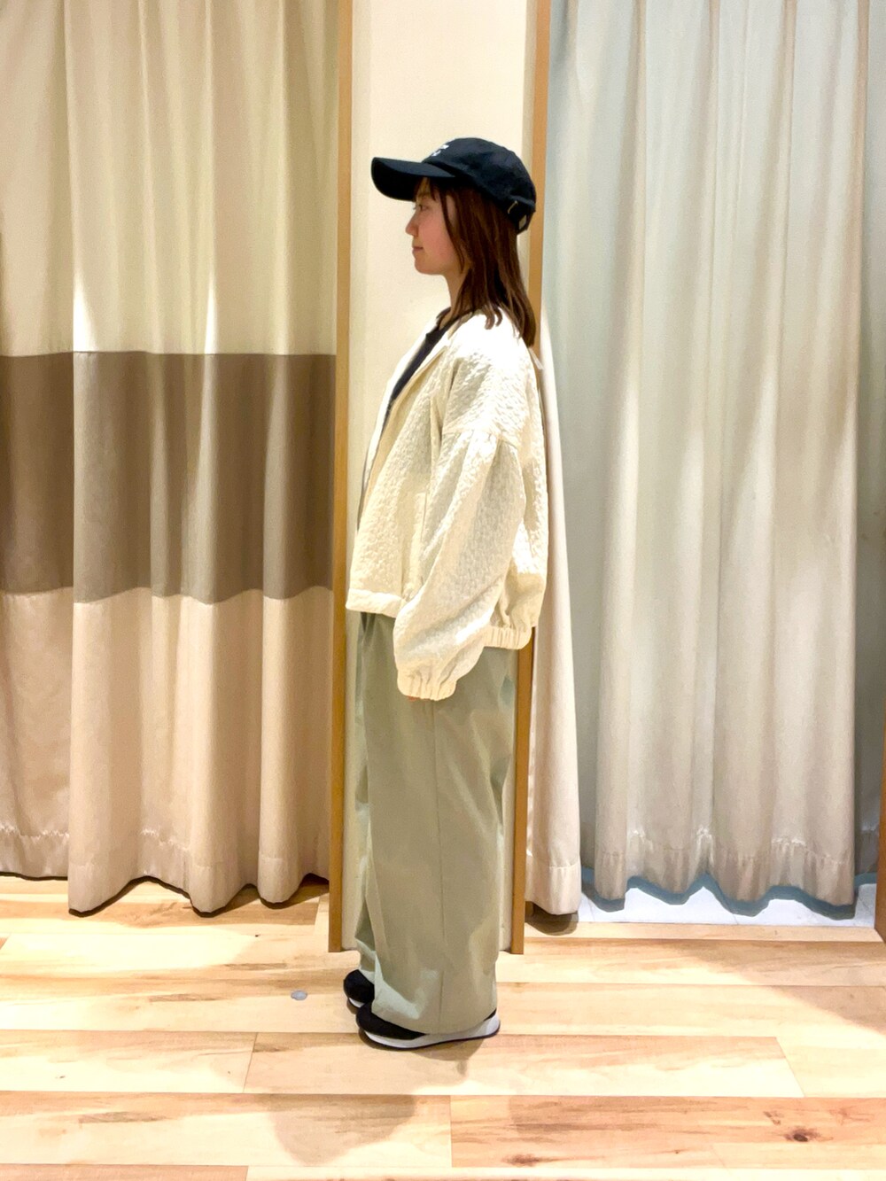 グレー系のTシャツ/カットソー、ホワイト系のブルゾン、グリーン系のその他パンツを着用したレディースの春コーディネートの3枚目の写真