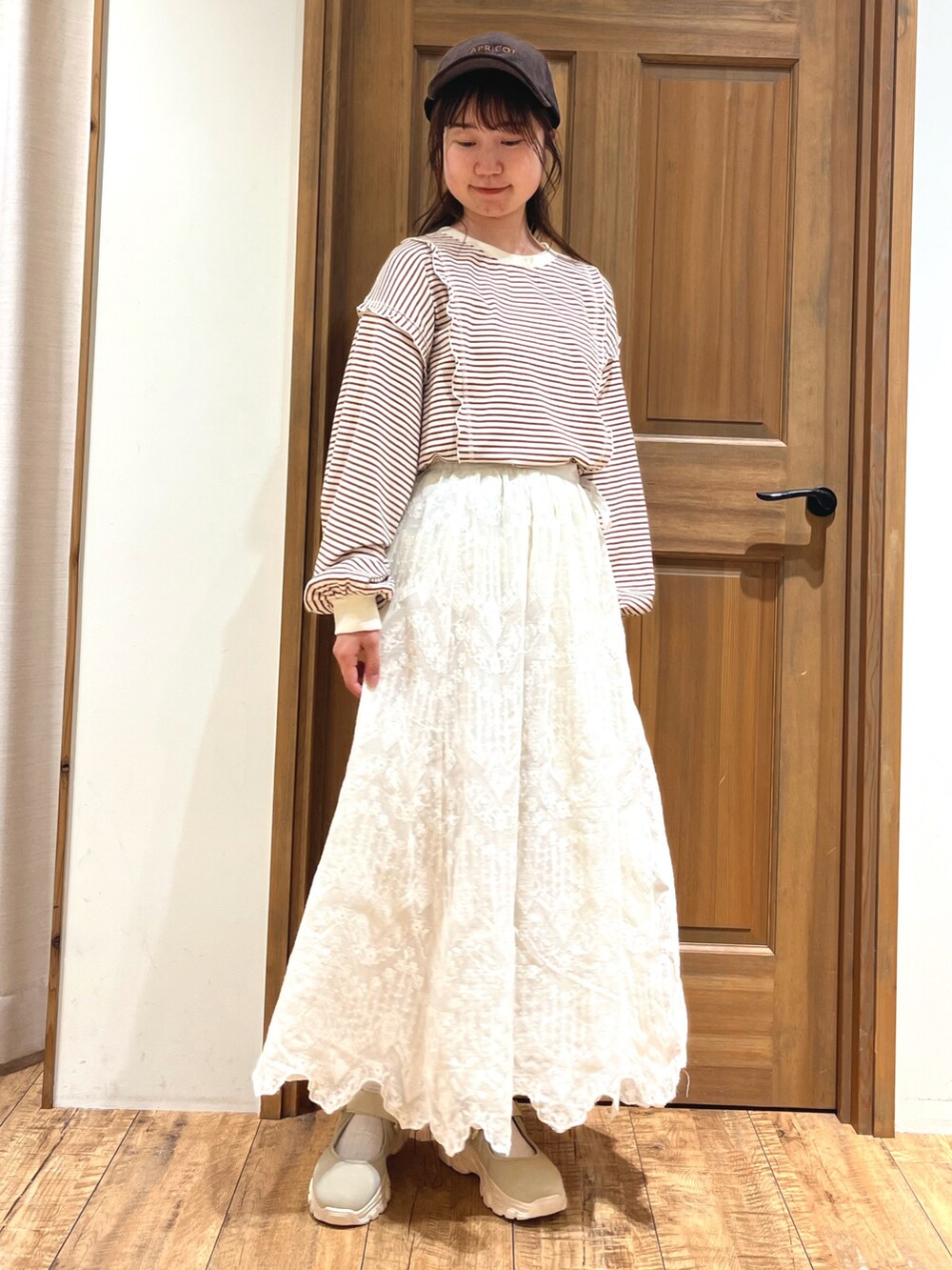 ベージュ系のドレスシューズ、ブラウン系のTシャツ/カットソー、ホワイト系のスカートを着用したレディースの秋コーディネートの5枚目の写真