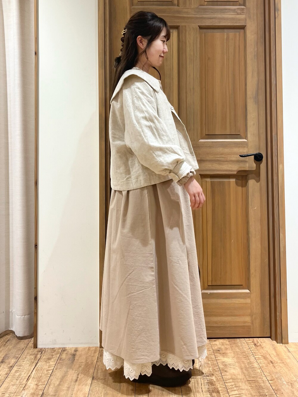 ブラウン系のブーツ、ブラウン系のハンドバッグ、ホワイト系のノーカラージャケットを着用したレディースの秋コーディネートの5枚目の写真