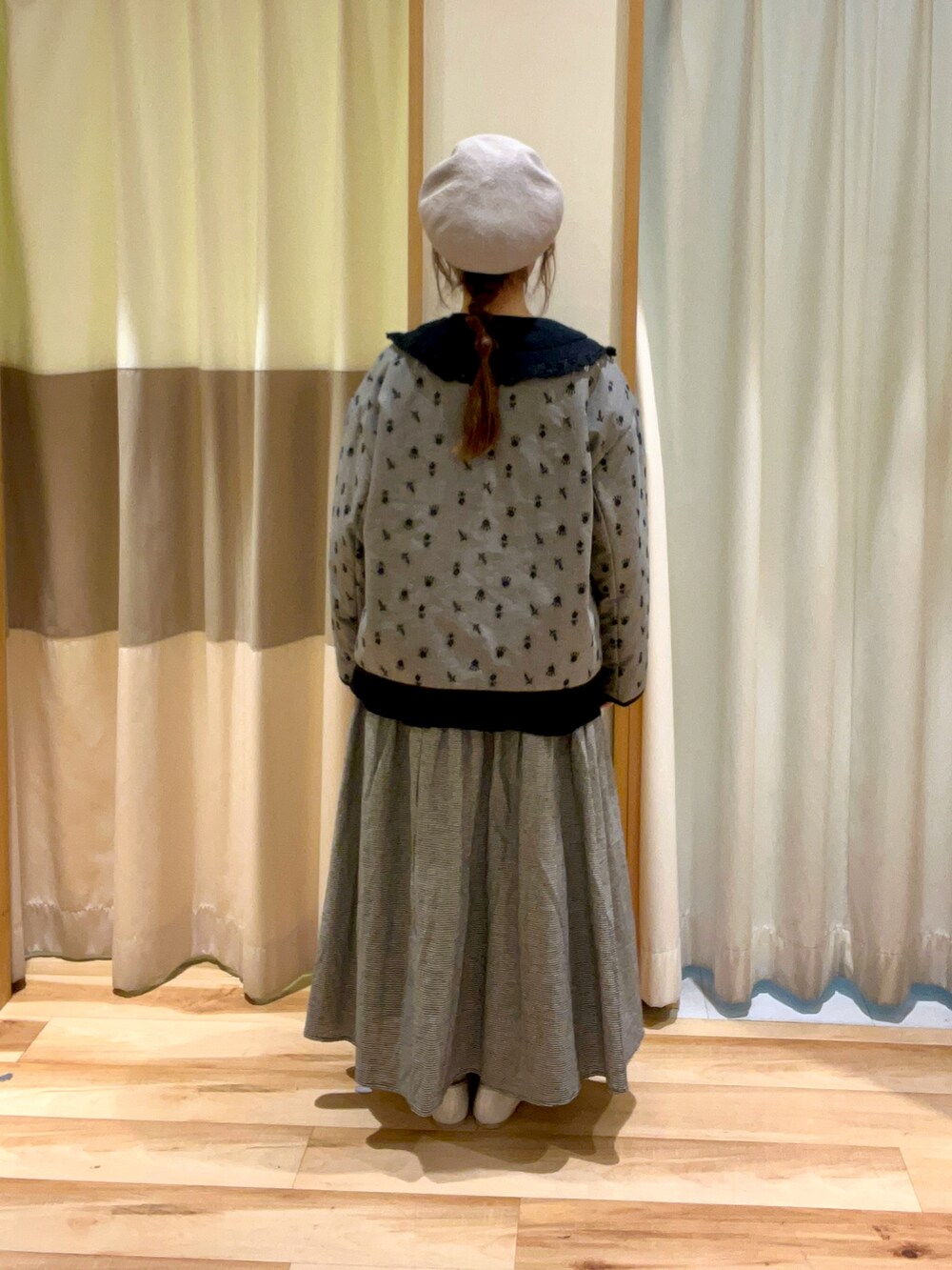 ブラック系のシャツ/ブラウス、グレー系のスカート、ホワイト系のパンプスを着用したレディースの冬コーディネートの3枚目の写真