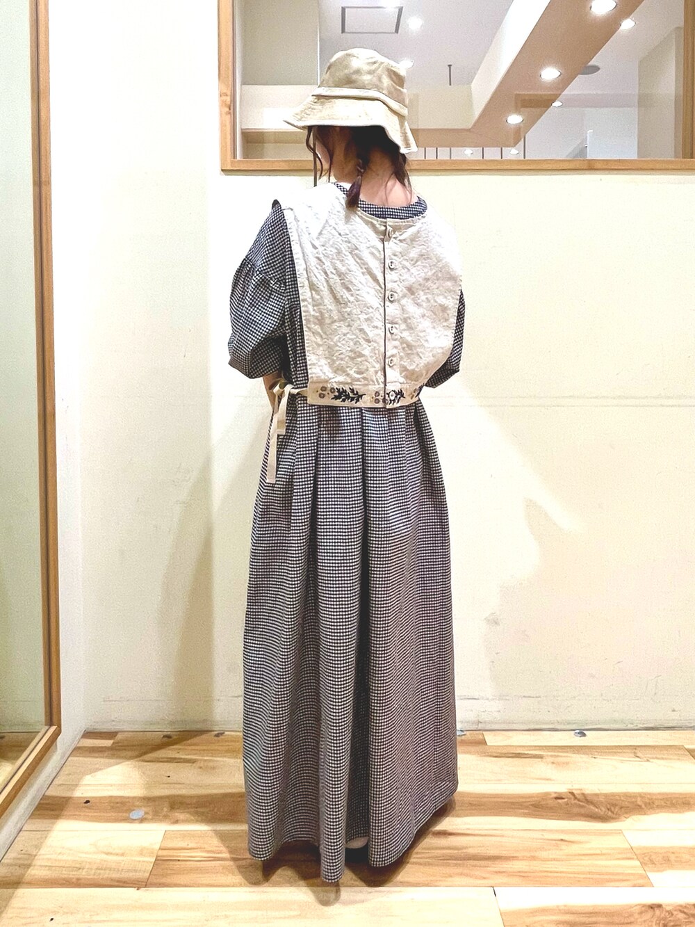 ベージュ系のベスト、ベージュ系のワンピース、ブラック系のサンダルを着用したレディースの春コーディネートの4枚目の写真