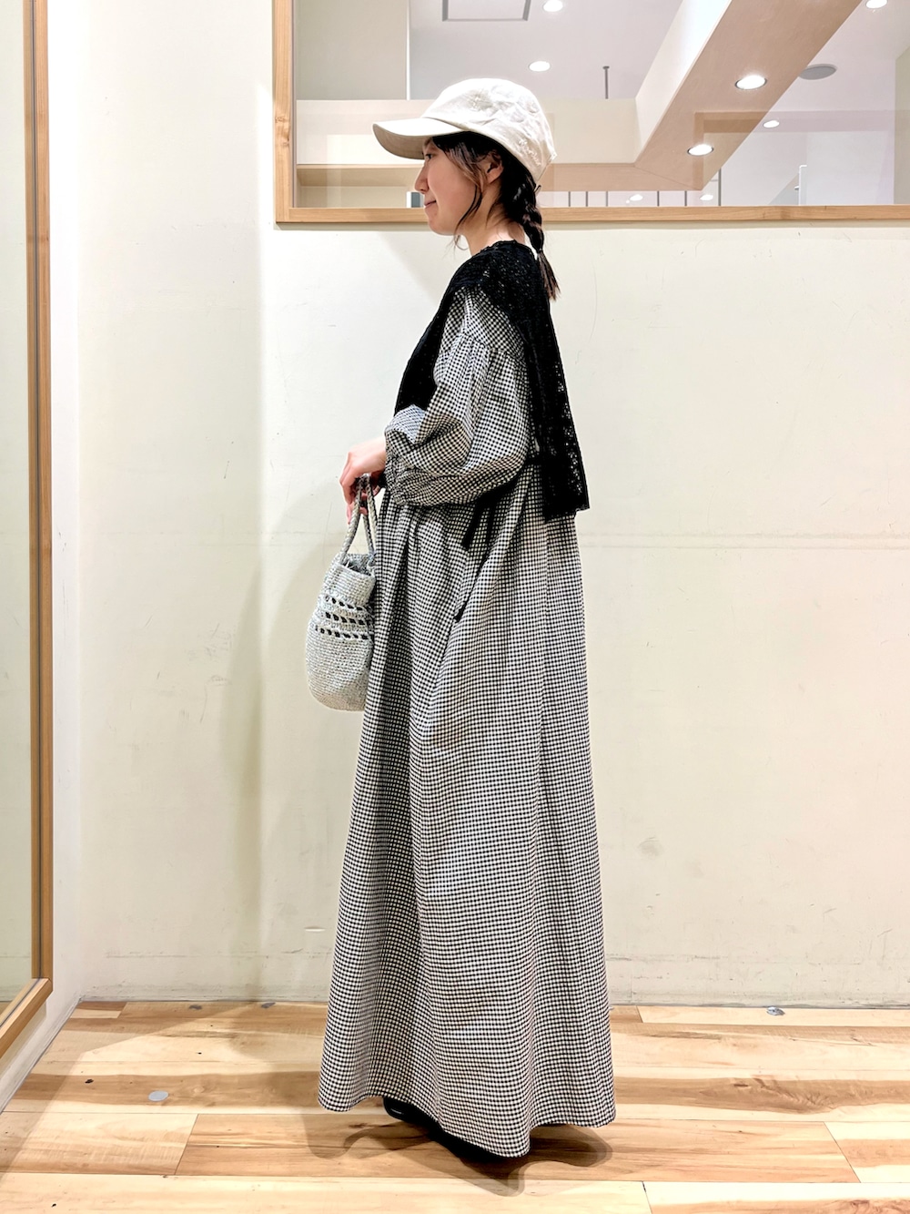 ベージュ系のワンピース、ブラック系のサンダル、シルバー系のハンドバッグを着用したレディースの春コーディネートの2枚目の写真