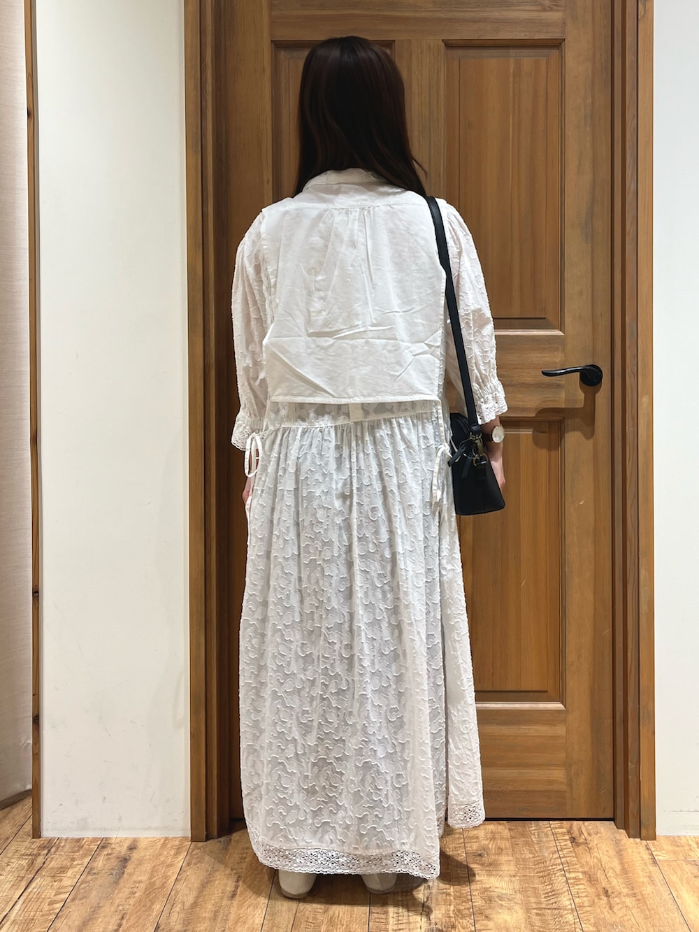 ブラック系のハンドバッグ、ブルー系のシャツ/ブラウス、ホワイト系のワンピースを着用したレディースの夏コーディネートの4枚目の写真