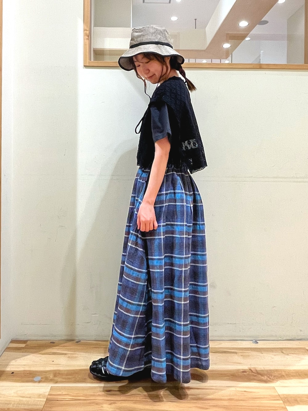 ベージュ系のワンピース、グレー系のTシャツ/カットソー、ブルー系のスカートを着用したレディースの春コーディネートの2枚目の写真