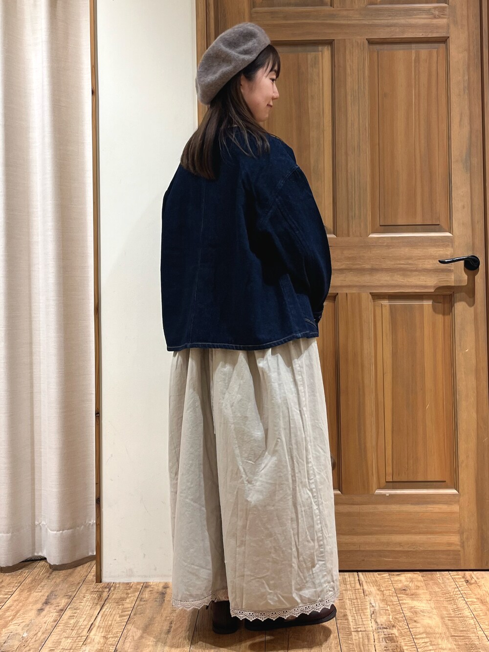 ブラウン系のドレスシューズ、ブルー系のノーカラージャケット、ベージュ系のワンピースを着用したレディースの秋コーディネートの5枚目の写真