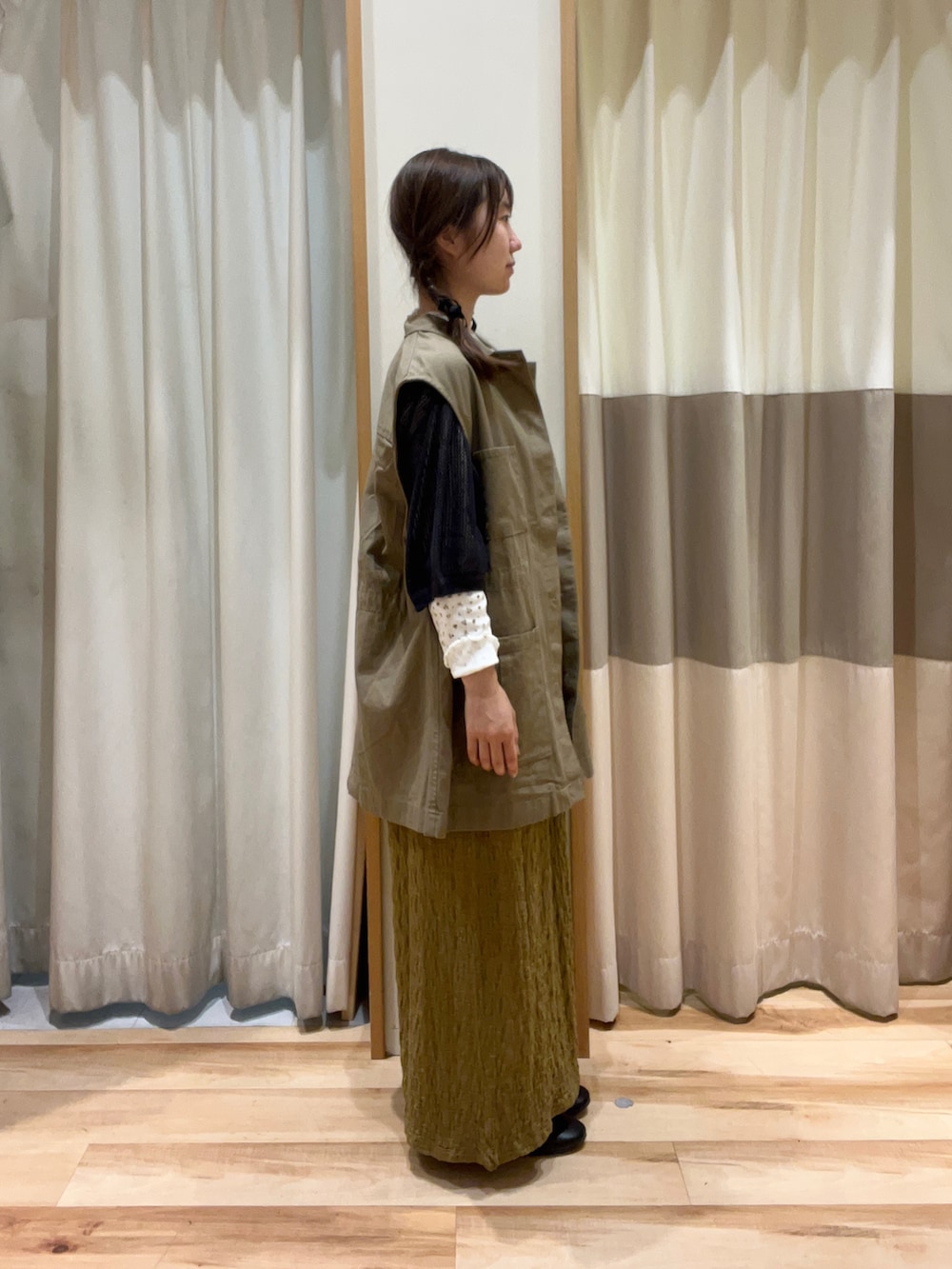 グレー系のニット/セーター、ベージュ系のワンピース、イエロー系のTシャツ/カットソーを着用したレディースの秋コーディネートの2枚目の写真