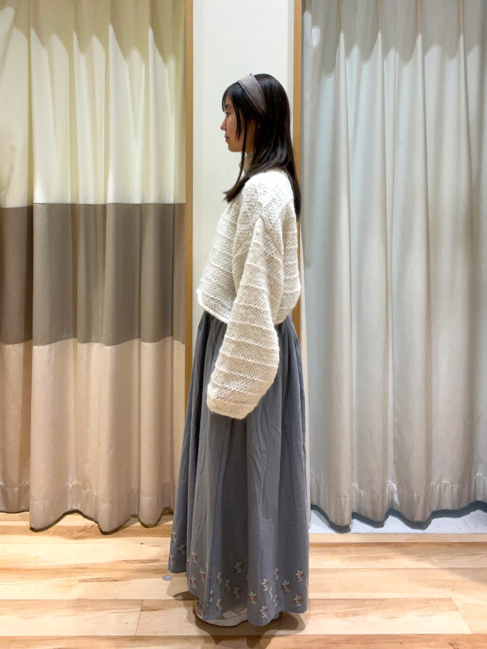 ホワイト系のTシャツ/カットソー、ホワイト系のニット/セーター、ブルー系のスカートを着用したレディースの秋コーディネートの2枚目の写真