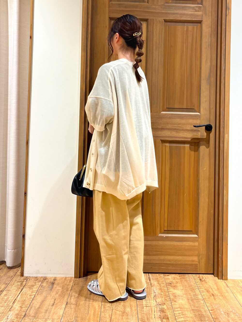 シルバー系のサンダル、ブラック系のハンドバッグ、ブラック系のTシャツ/カットソーを着用したレディースの夏コーディネートの4枚目の写真