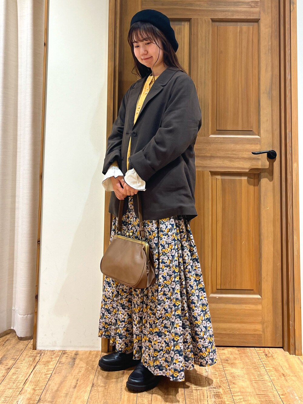 ブラウン系のハンドバッグ、イエロー系のカーディガン/ボレロ、グレー系のノーカラージャケットを着用したレディースの秋コーディネートの2枚目の写真