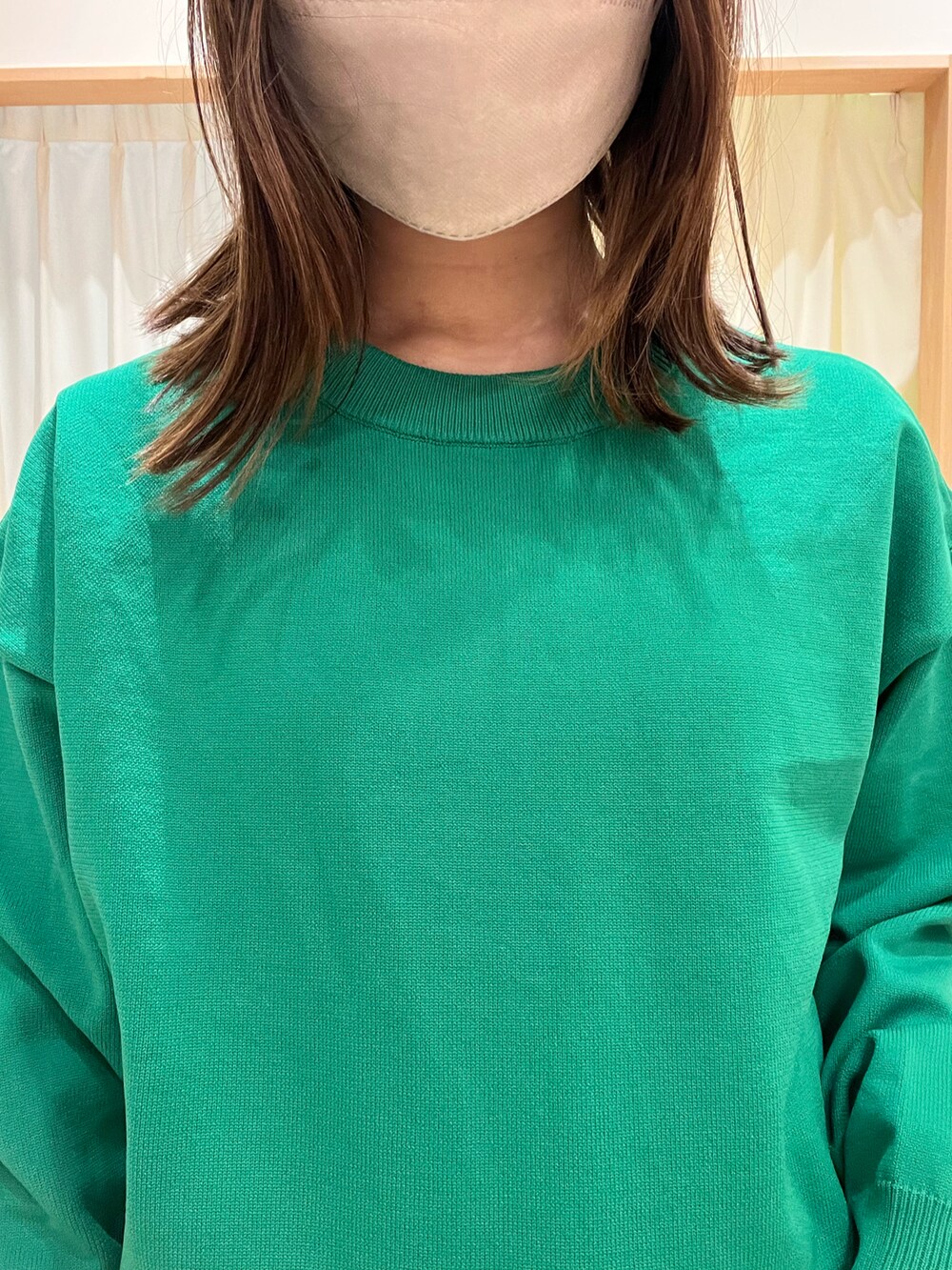 グリーン系のカーディガン/ボレロ、グレー系のチノパンツを着用したレディースの冬コーディネートの2枚目の写真