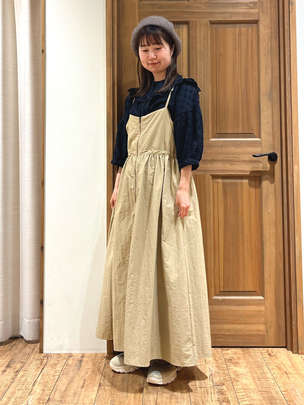 ベージュ系のスニーカー、ブラック系のシャツ/ブラウス、ベージュ系のワンピースを着用したレディースの秋コーディネートの2枚目の写真