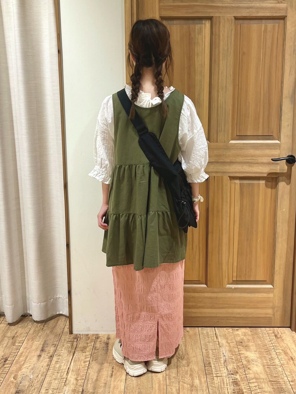 ベージュ系のドレスシューズ、レッド系のスカート、ブラック系のハンドバッグを着用したレディースの秋コーディネートの3枚目の写真