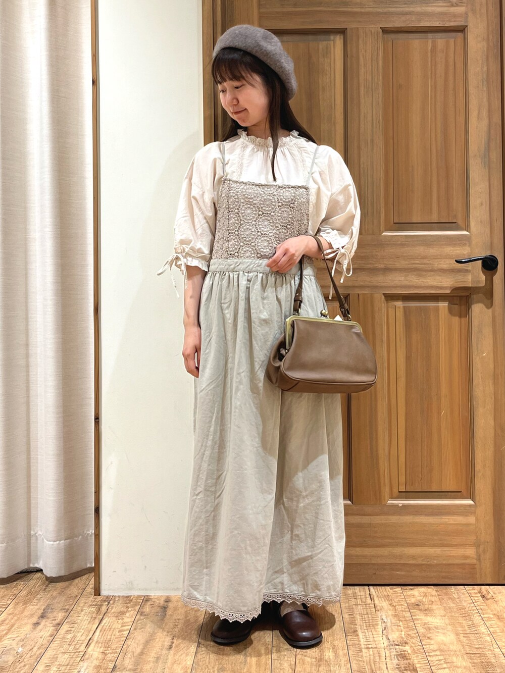 ブラウン系のドレスシューズ、ホワイト系のシャツ/ブラウス、ベージュ系のワンピースを着用したレディースの秋コーディネートの2枚目の写真
