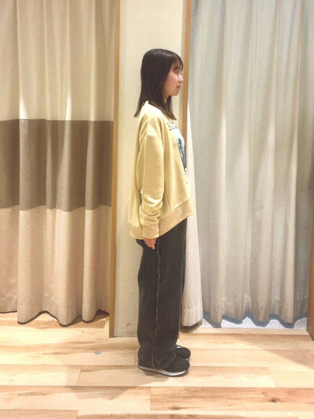 グレー系のデニムパンツ、ホワイト系のハンドバッグ、ベージュ系のTシャツ/カットソーを着用したレディースの春コーディネートの3枚目の写真