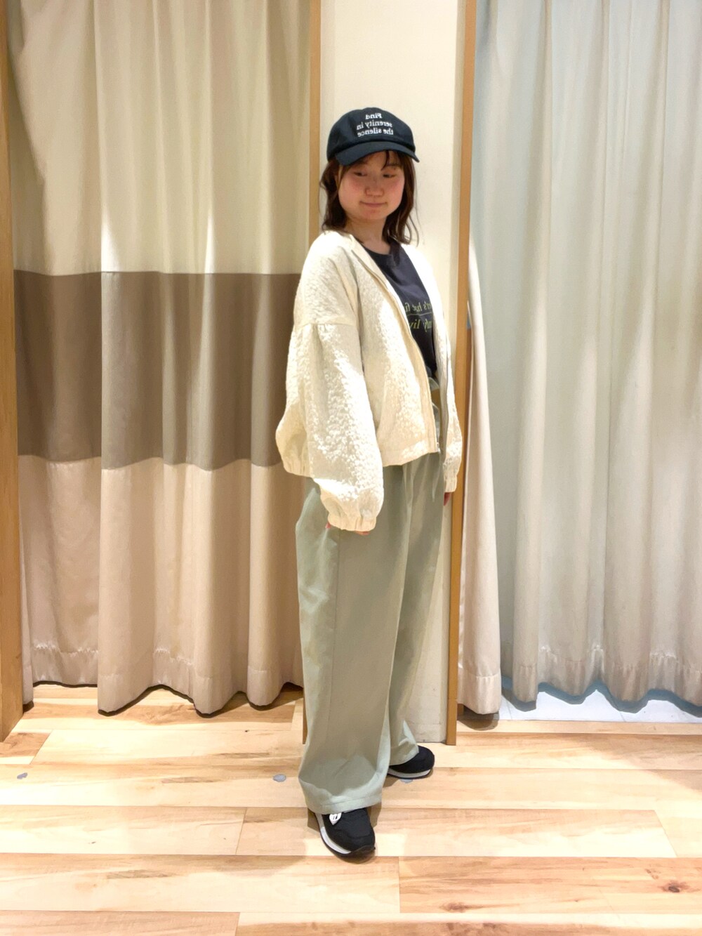 グレー系のTシャツ/カットソー、ホワイト系のブルゾン、グリーン系のその他パンツを着用したレディースの春コーディネートの2枚目の写真