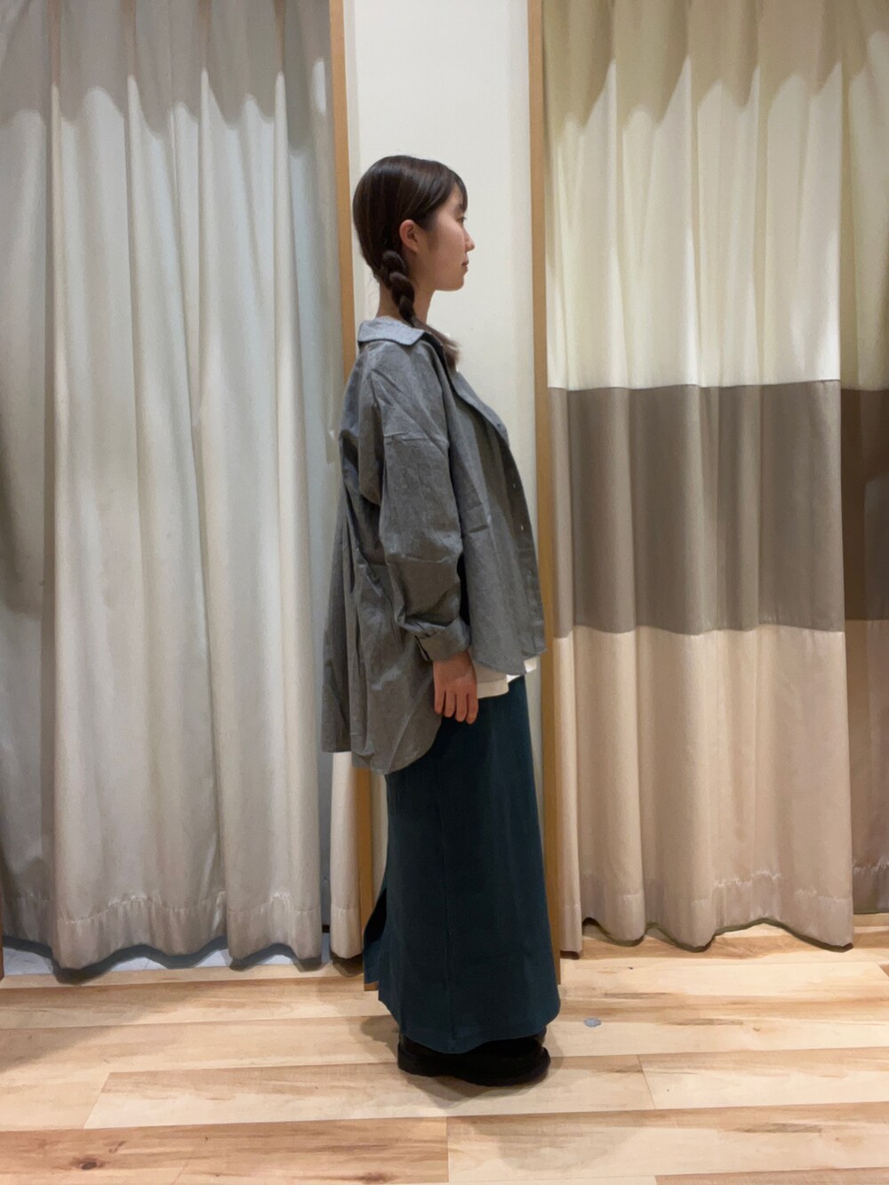 ホワイト系のTシャツ/カットソー、ブラック系のハンドバッグ、グリーン系のスカートを着用したレディースの秋コーディネートの2枚目の写真