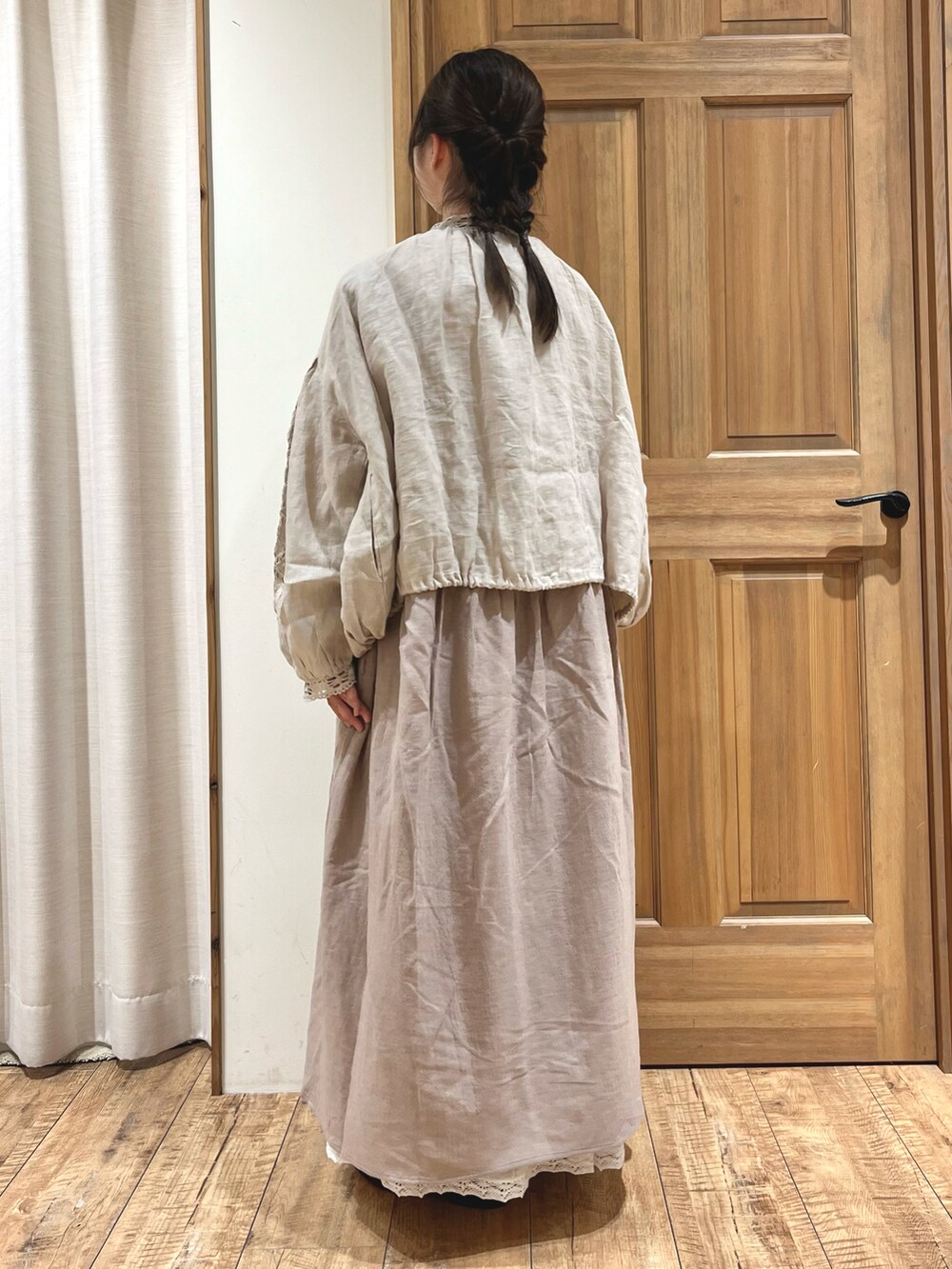 ブラック系のブーツ、ホワイト系のスカート、ベージュ系のノーカラージャケットを着用したレディースの秋コーディネートの4枚目の写真