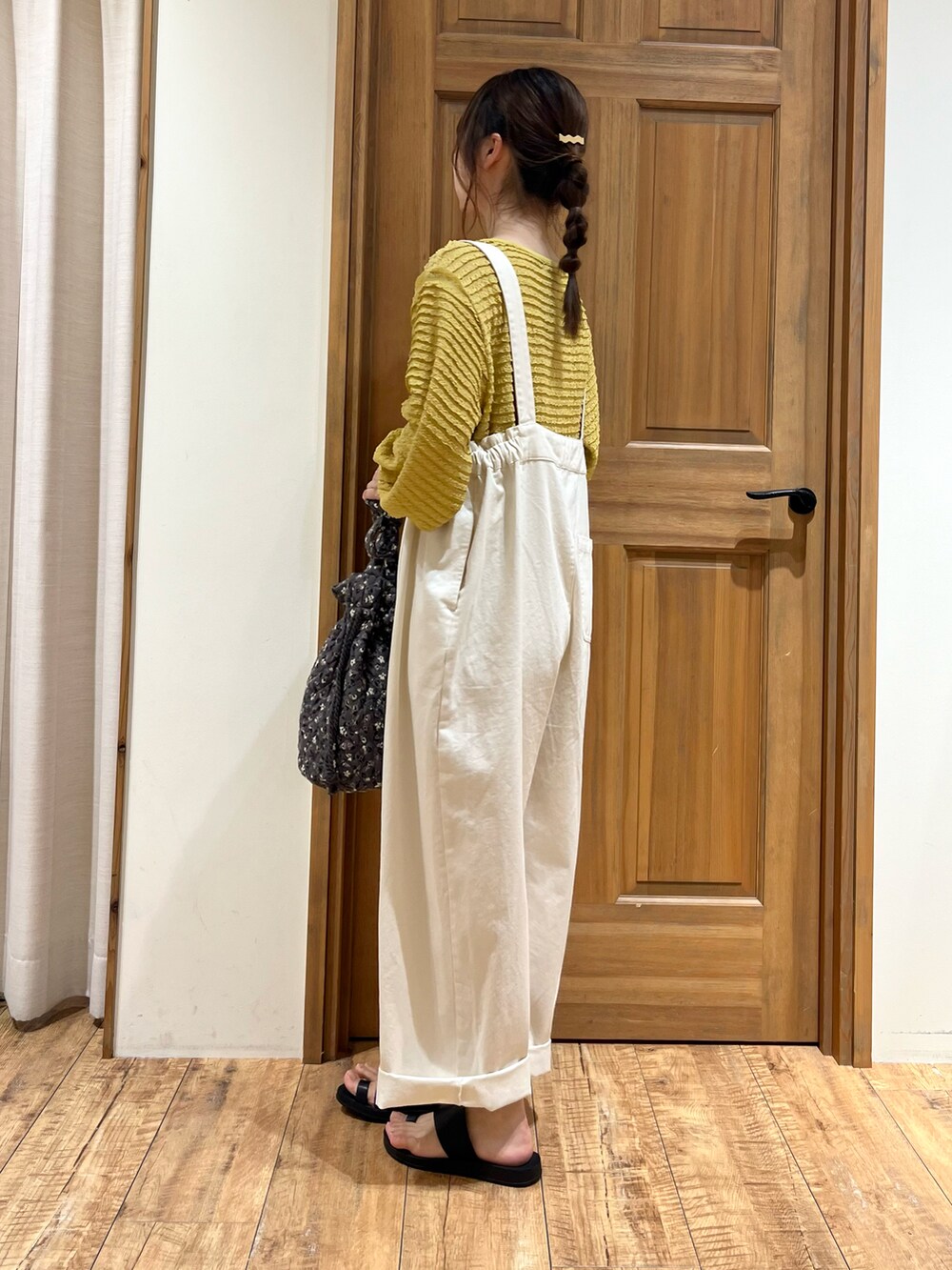 グレー系のハンドバッグ、ホワイト系のその他パンツ、イエロー系のカーディガン/ボレロを着用したレディースの夏コーディネートの2枚目の写真