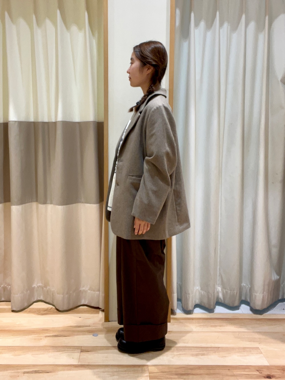 ブルー系のシャツ/ブラウス、グレー系のTシャツ/カットソー、ブラウン系のノーカラージャケットを着用したレディースの秋コーディネートの2枚目の写真