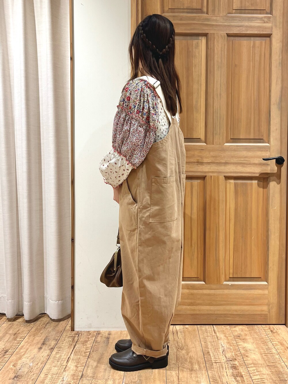 ブラウン系のハンドバッグ、ベージュ系のサロペット/オーバーオール、ホワイト系のシャツ/ブラウスを着用したレディースの秋コーディネートの2枚目の写真