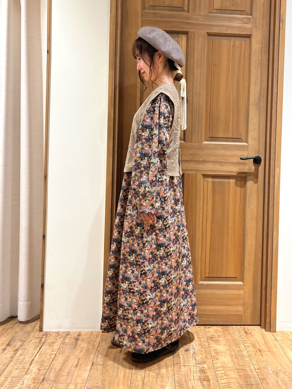 ブラウン系のドレスシューズ、ベージュ系のベスト、ピンク系のワンピースを着用したレディースの夏コーディネートの3枚目の写真