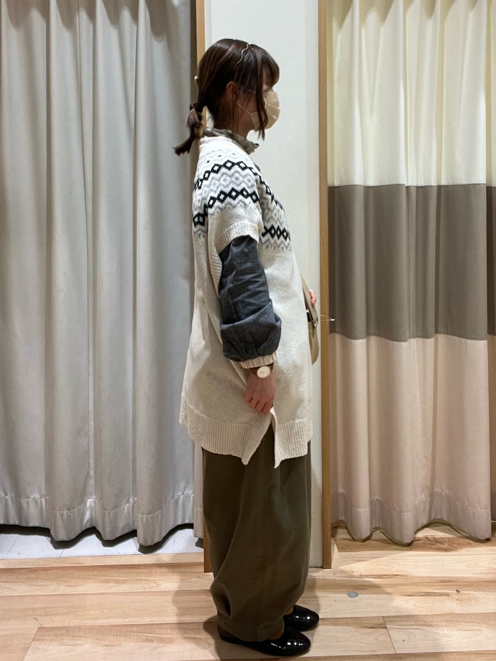 グリーン系のその他パンツ、ベージュ系のショルダーバッグ、ホワイト系のベストを着用したレディースの冬コーディネートの2枚目の写真