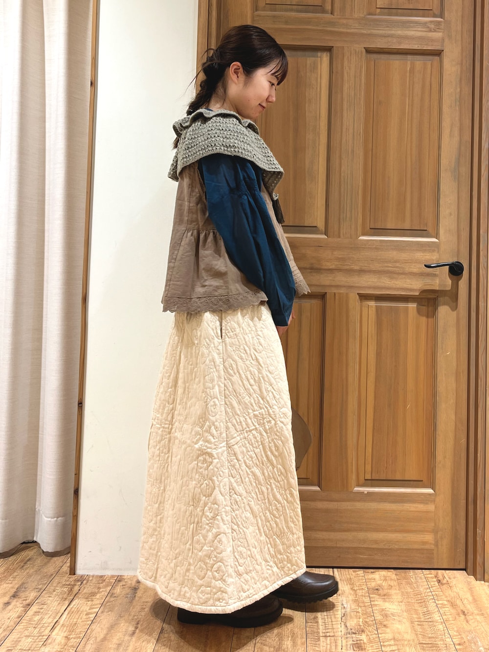 ブラウン系のハンドバッグ、ブラウン系のベスト、ブルー系のシャツ/ブラウスを着用したレディースの秋コーディネートの5枚目の写真