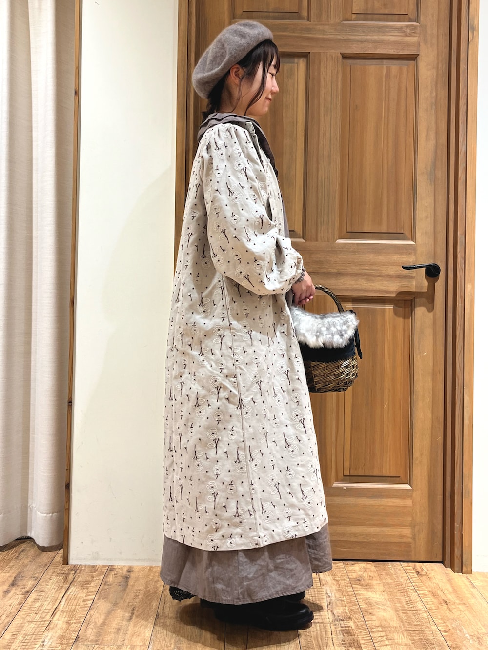 ブラウン系のバッグ、ブラック系のブーツ、グレー系のワンピースを着用したレディースの秋コーディネートの5枚目の写真