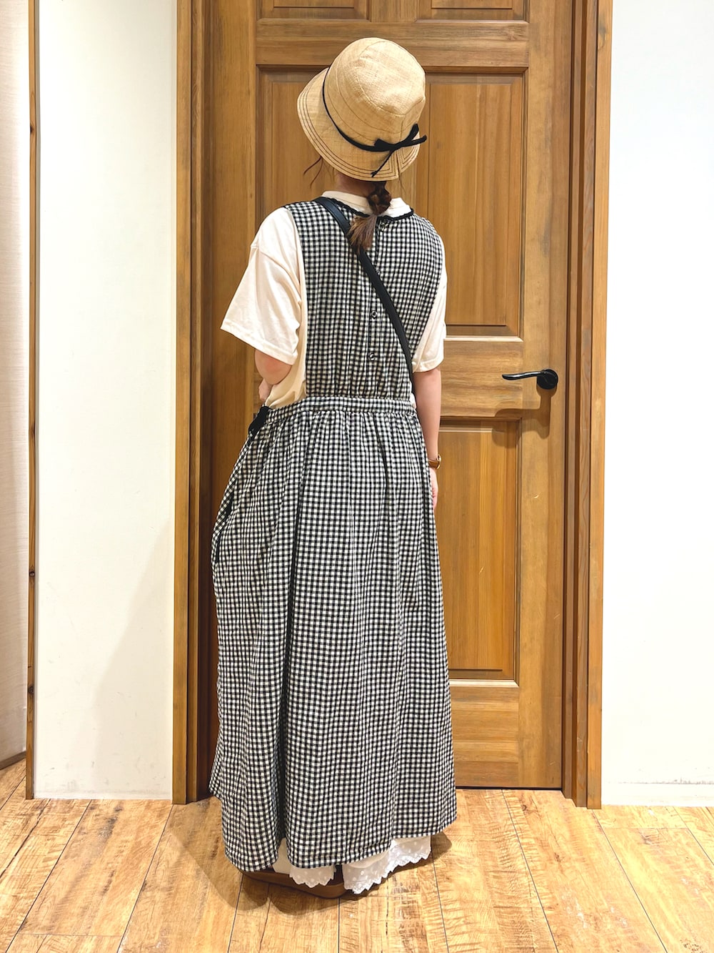 ブラック系のハンドバッグ、ブラック系のワンピース、ホワイト系のスカートを着用したレディースの夏コーディネートの3枚目の写真