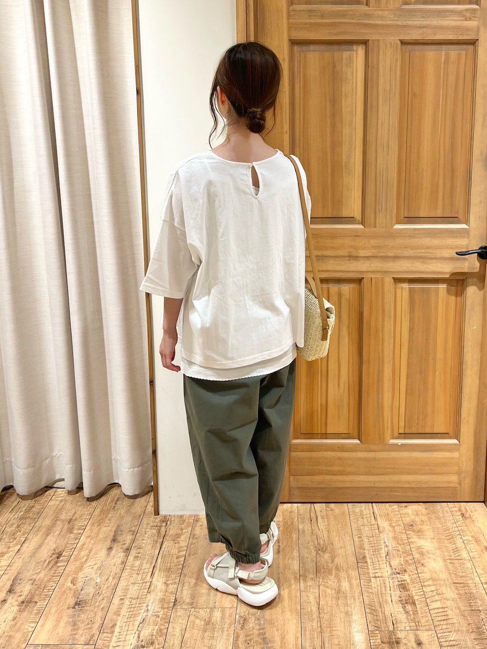 ホワイト系のハンドバッグ、ホワイト系のキャミソール、ホワイト系のTシャツ/カットソーを着用したレディースの夏コーディネートの3枚目の写真