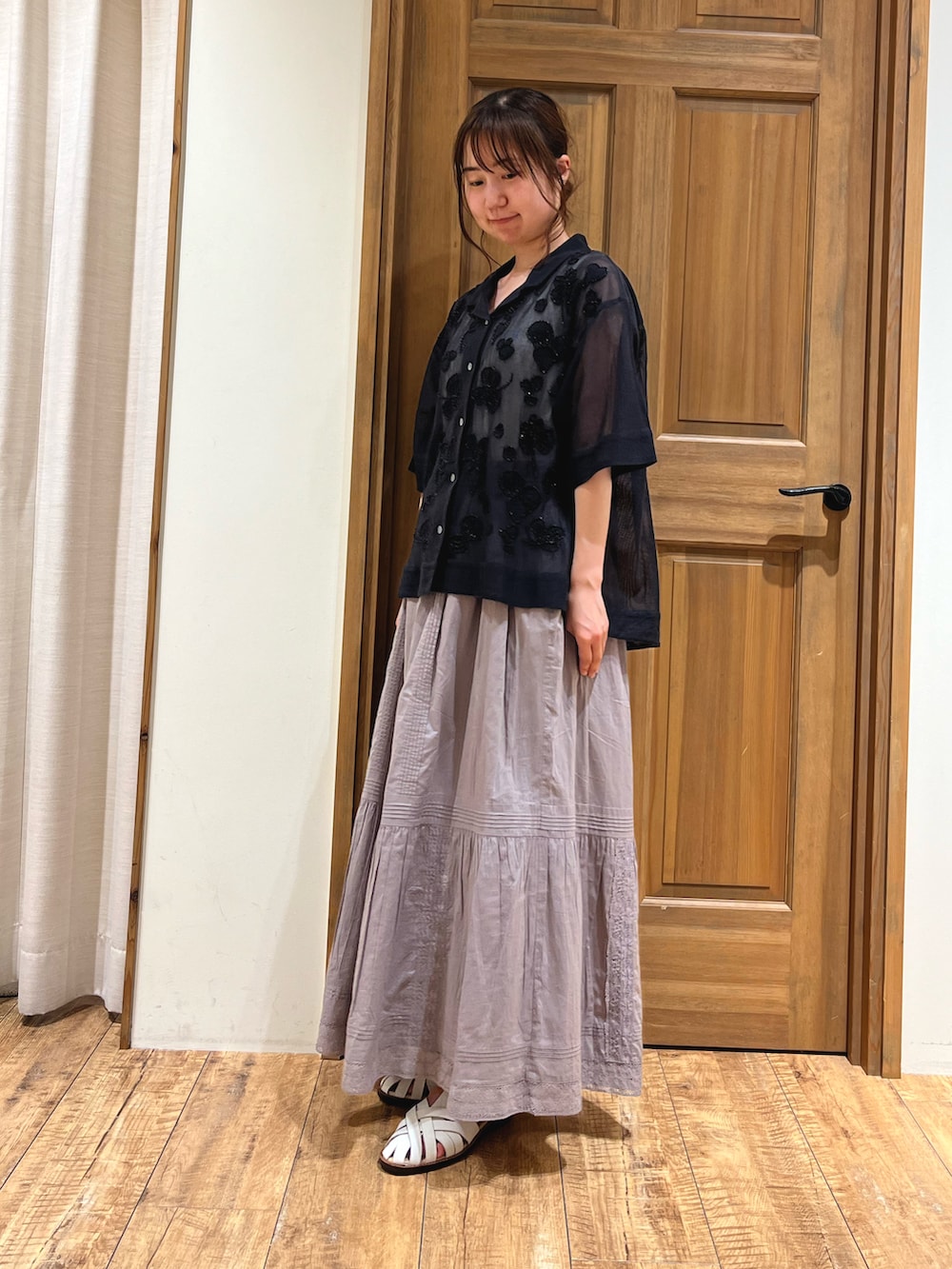 ホワイト系のサンダル、グレー系のスカート、ブラック系のシャツ/ブラウスを着用したレディースの夏コーディネートの2枚目の写真