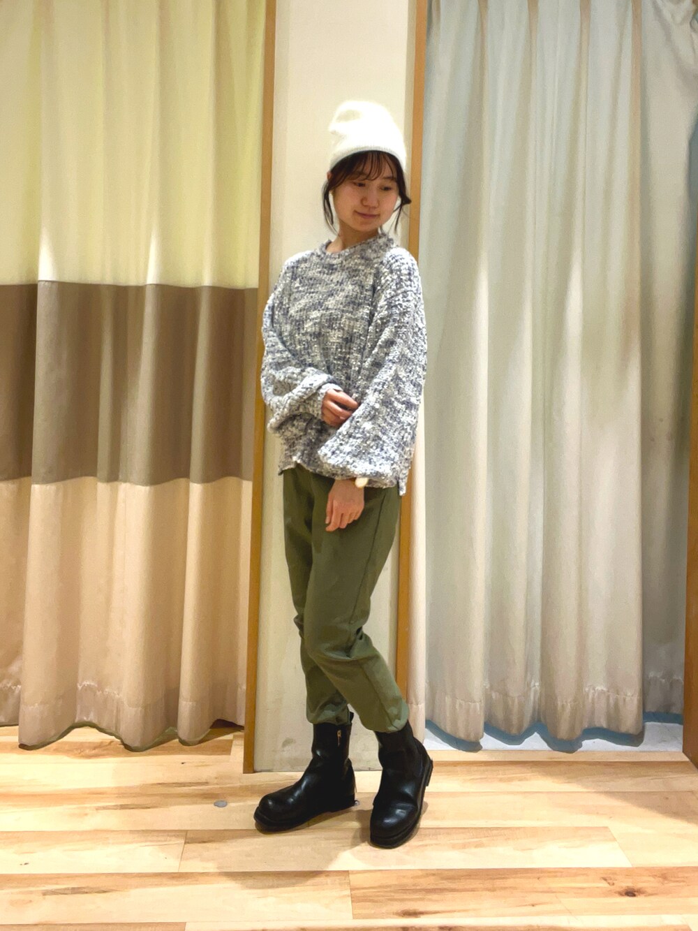 グリーン系のその他パンツ、グレー系のニット/セーター、ホワイト系のハットを着用したレディースの冬コーディネートの2枚目の写真