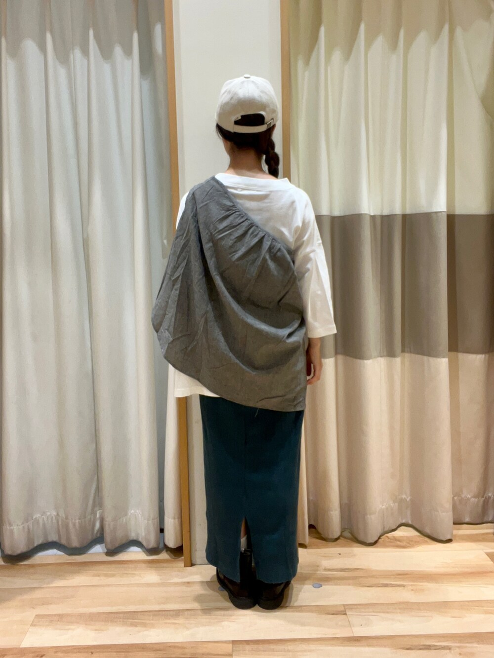 グリーン系のスカート、ブラック系のブーツ、ブラック系のシャツ/ブラウスを着用したレディースの秋コーディネートの3枚目の写真