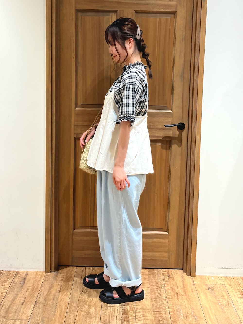 ホワイト系のハンドバッグ、ブルー系のその他パンツ、ブラック系のサンダルを着用したレディースの夏コーディネートの2枚目の写真