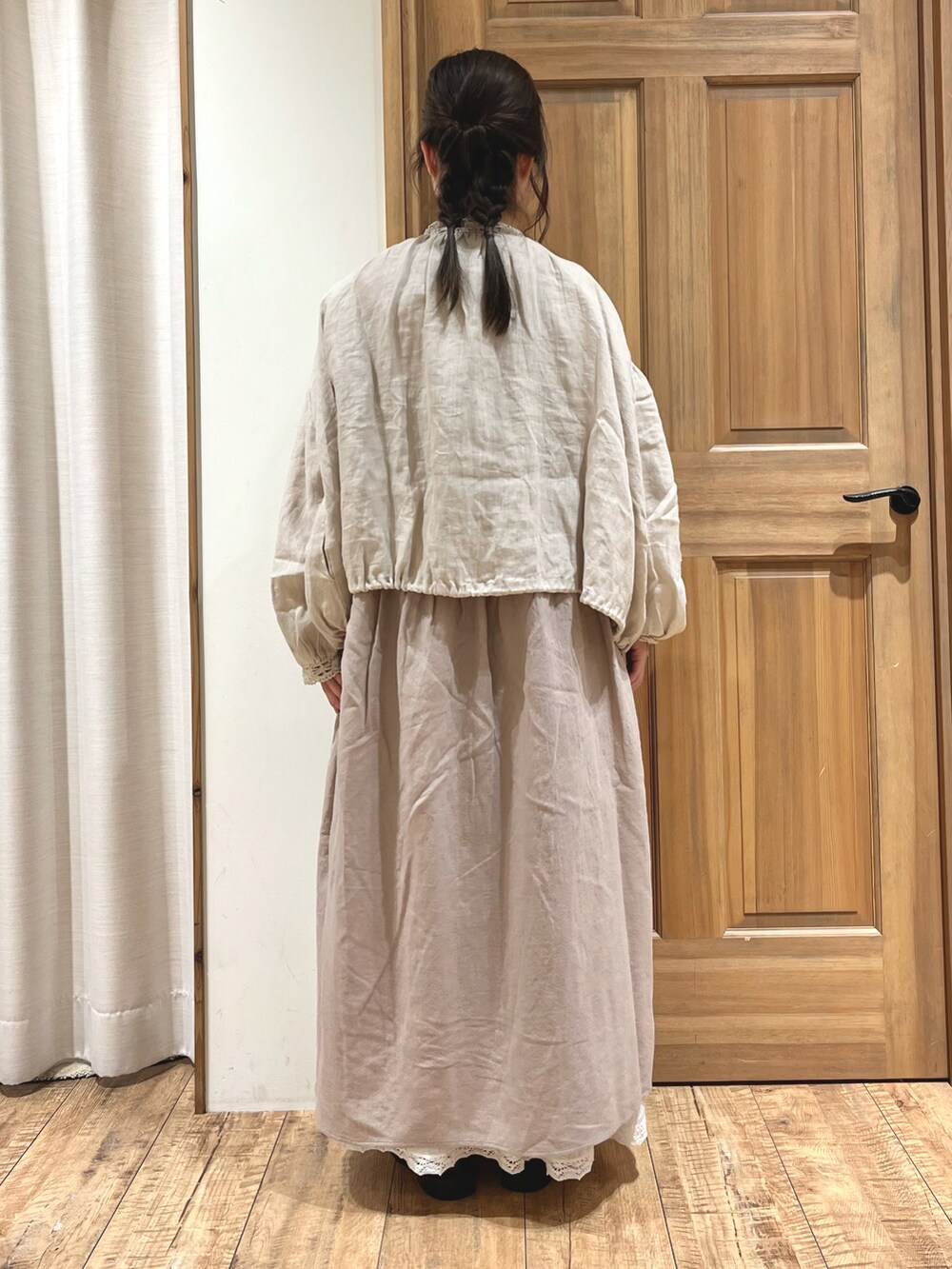 ブラック系のブーツ、ホワイト系のスカート、ベージュ系のノーカラージャケットを着用したレディースの秋コーディネートの5枚目の写真