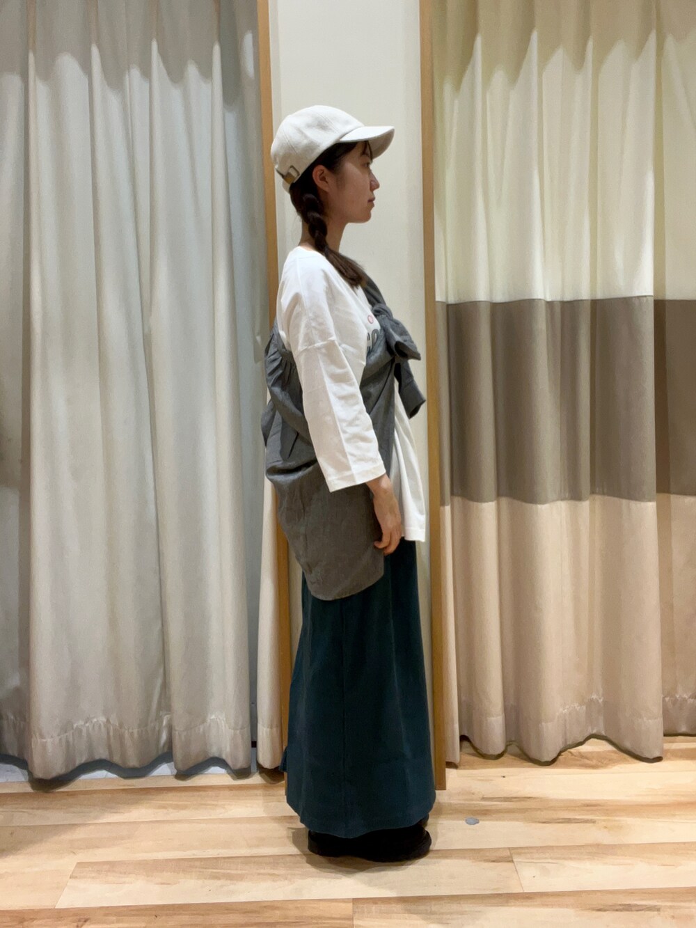 グリーン系のスカート、ブラック系のブーツ、ブラック系のシャツ/ブラウスを着用したレディースの秋コーディネートの2枚目の写真