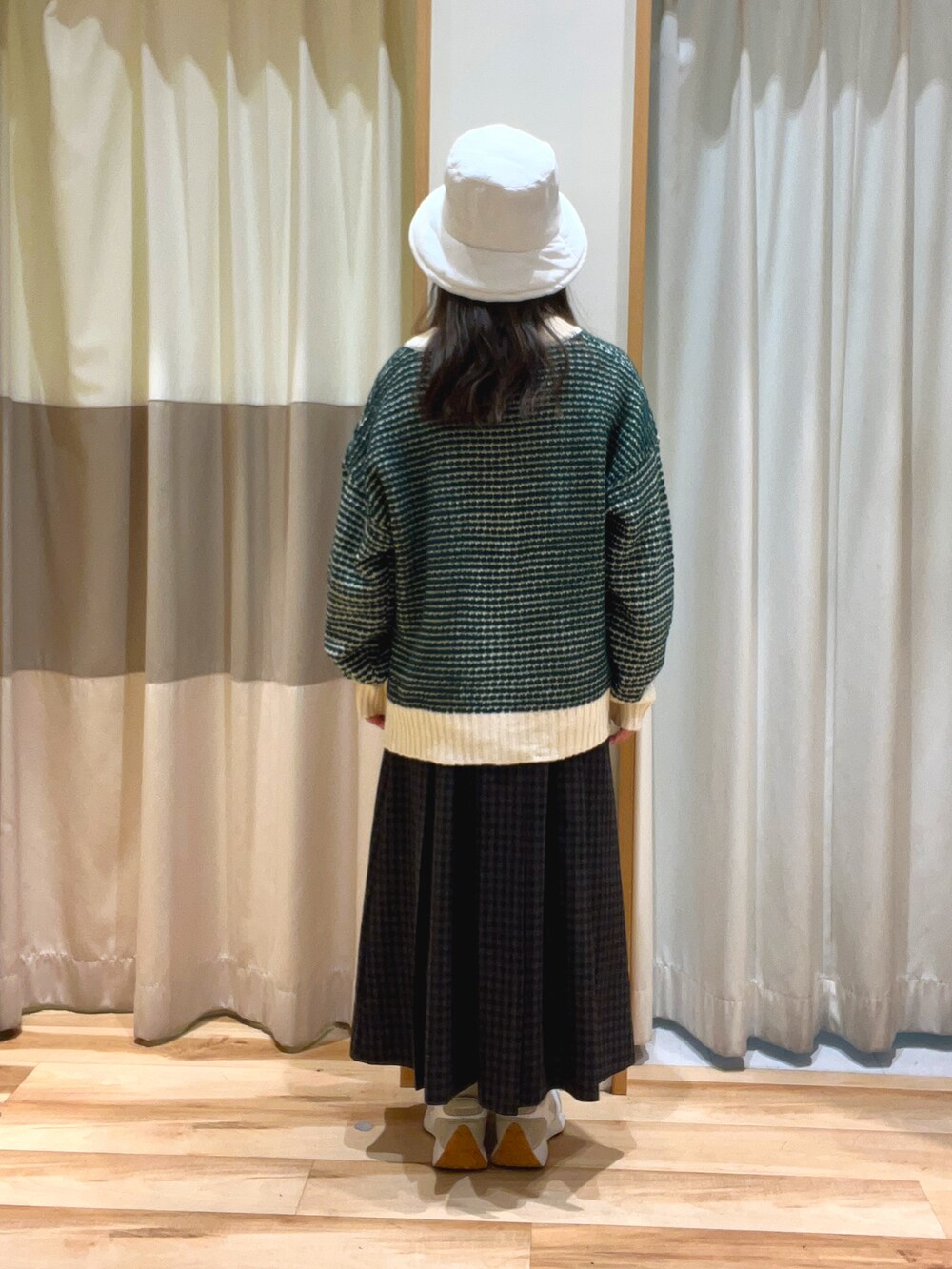 ホワイト系のシャツ/ブラウス、グリーン系のカーディガン/ボレロ、グレー系のスカートを着用したレディースの秋コーディネートの3枚目の写真