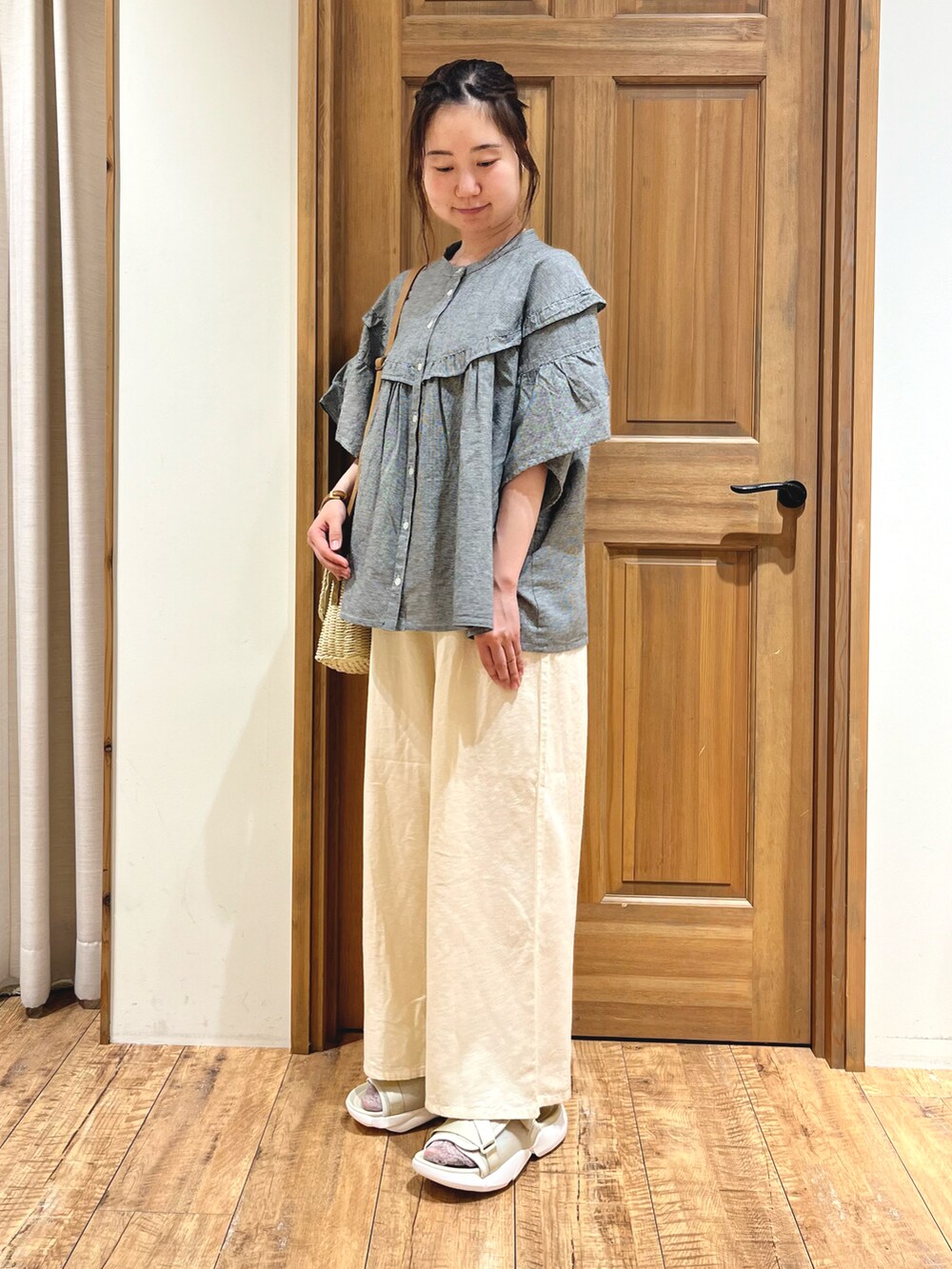 ホワイト系のハンドバッグ、グレー系のシャツ/ブラウス、ホワイト系のその他パンツを着用したレディースの夏コーディネートの2枚目の写真