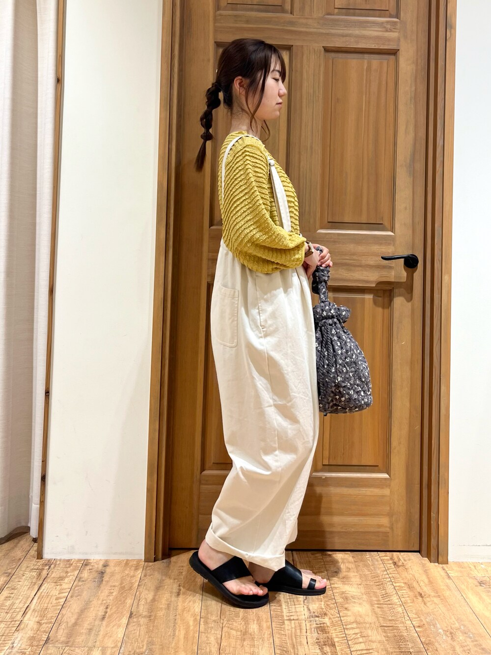 グレー系のハンドバッグ、ホワイト系のその他パンツ、イエロー系のカーディガン/ボレロを着用したレディースの夏コーディネートの5枚目の写真