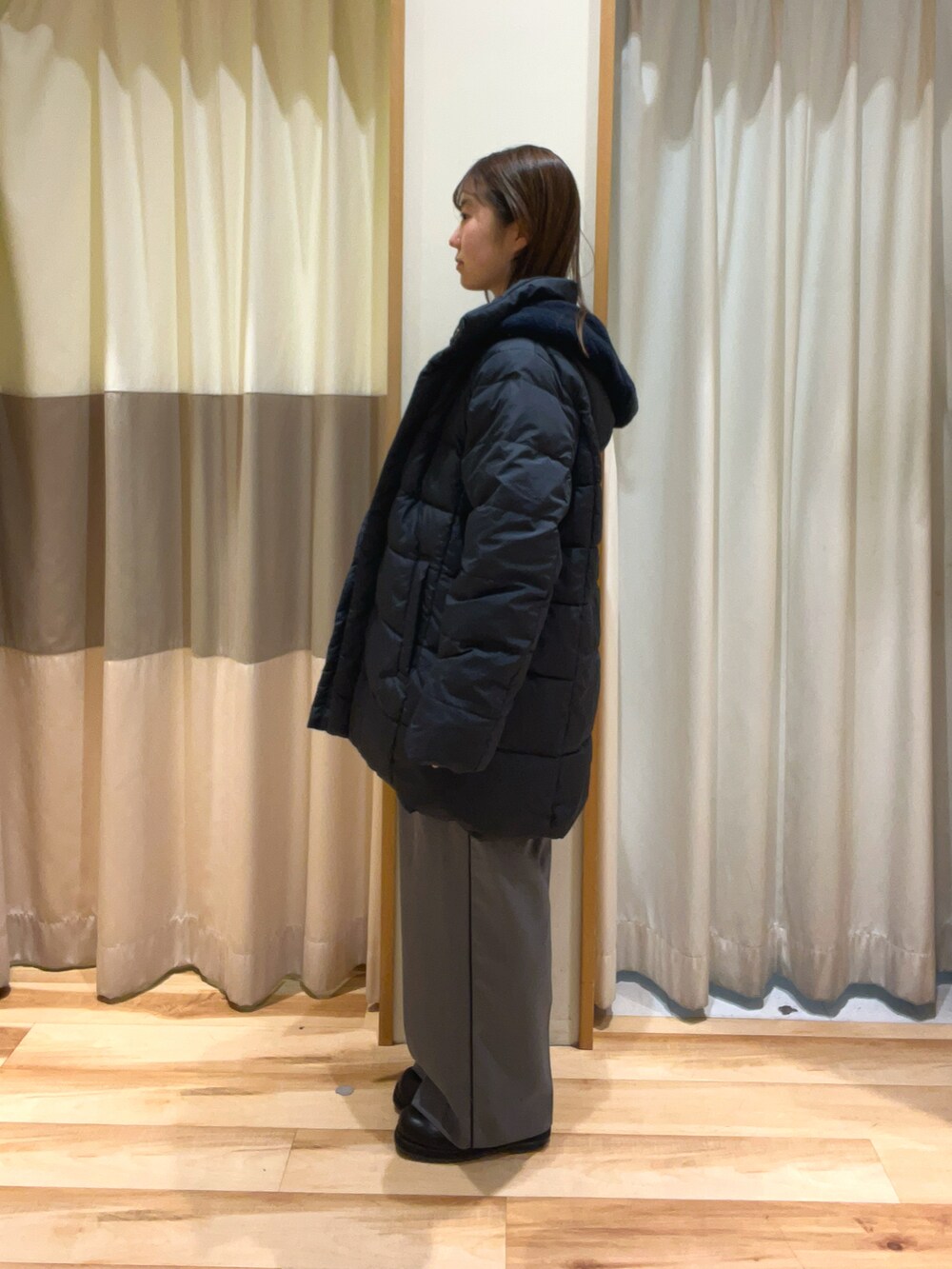 ブルー系のニット/セーター、グレー系のハンドバッグ、グレー系のその他パンツを着用したレディースの秋コーディネートの3枚目の写真